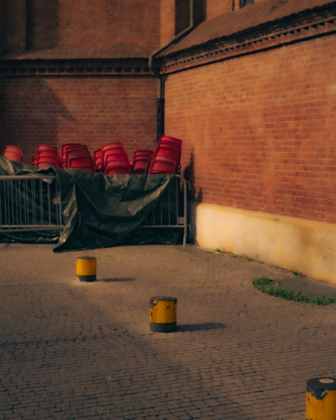 black and red metal chairs beside brown brick wall