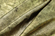 A textured black fabric draped elegantly, with antique gold threads catching the light subtly.