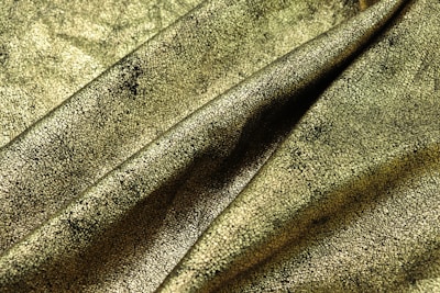 A detailed close-up of a richly textured costume fabric draped on a mannequin backstage.