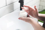 Hands gently applying a creamy moisturizer, highlighting skin softness.