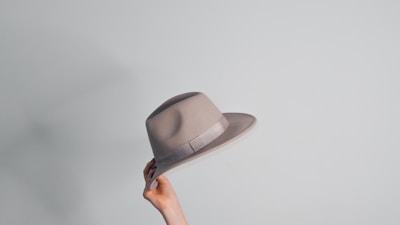 a woman's hand holding a gray hat