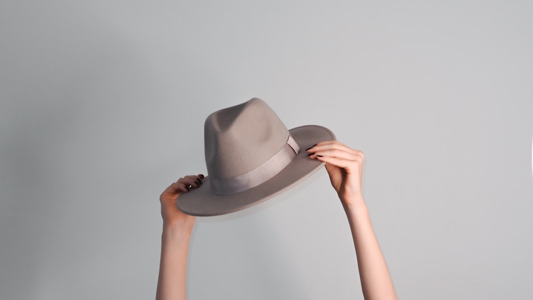 person holding white fedora hat