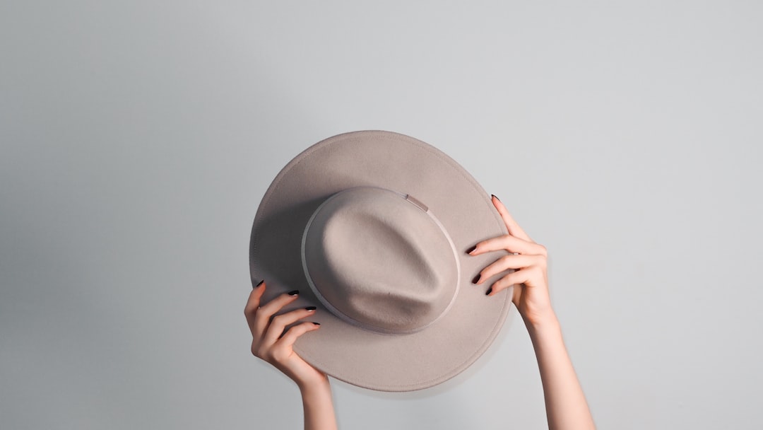 person holding gray fedora hat
