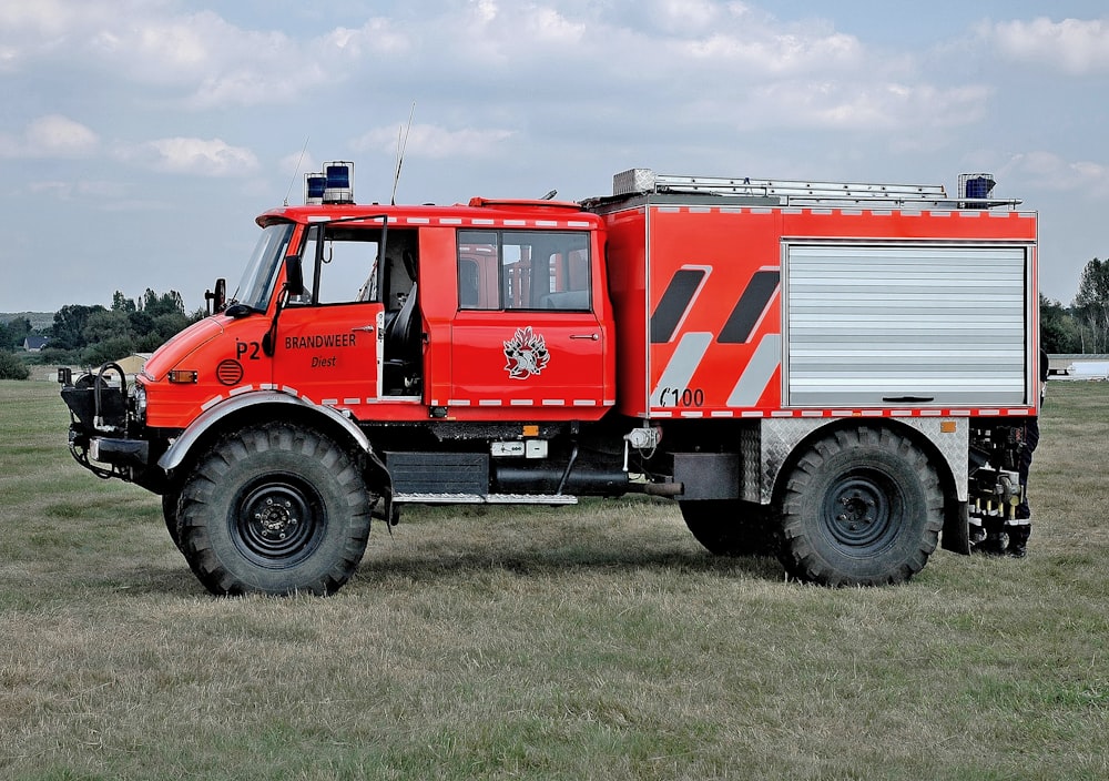 red and white truck on green grass field during daytime