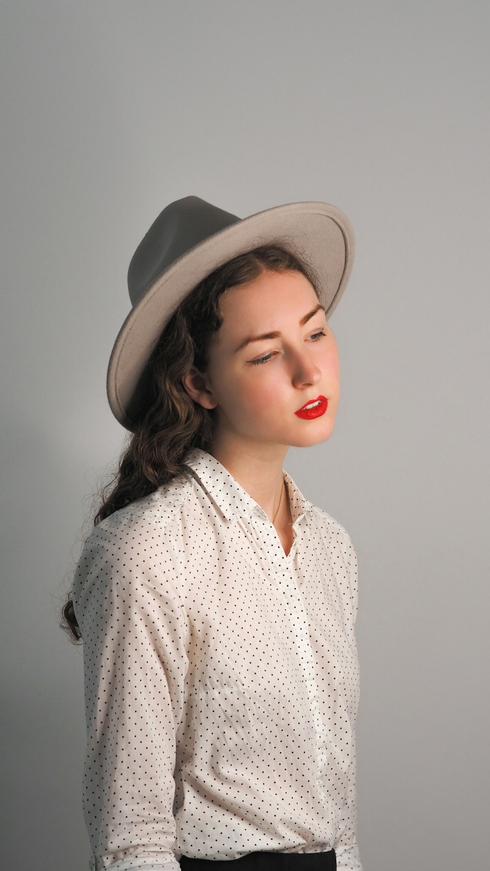 woman in white and black button up shirt wearing brown hat