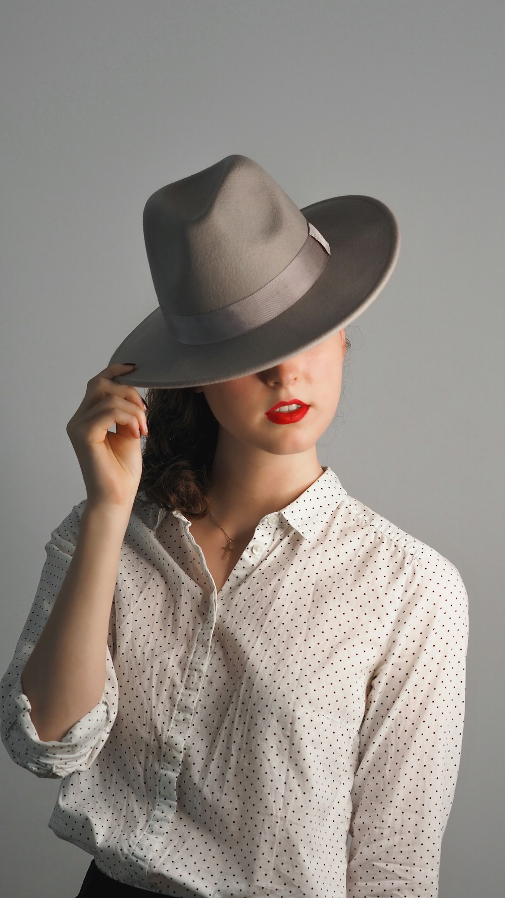 woman in grey button up shirt wearing grey hat