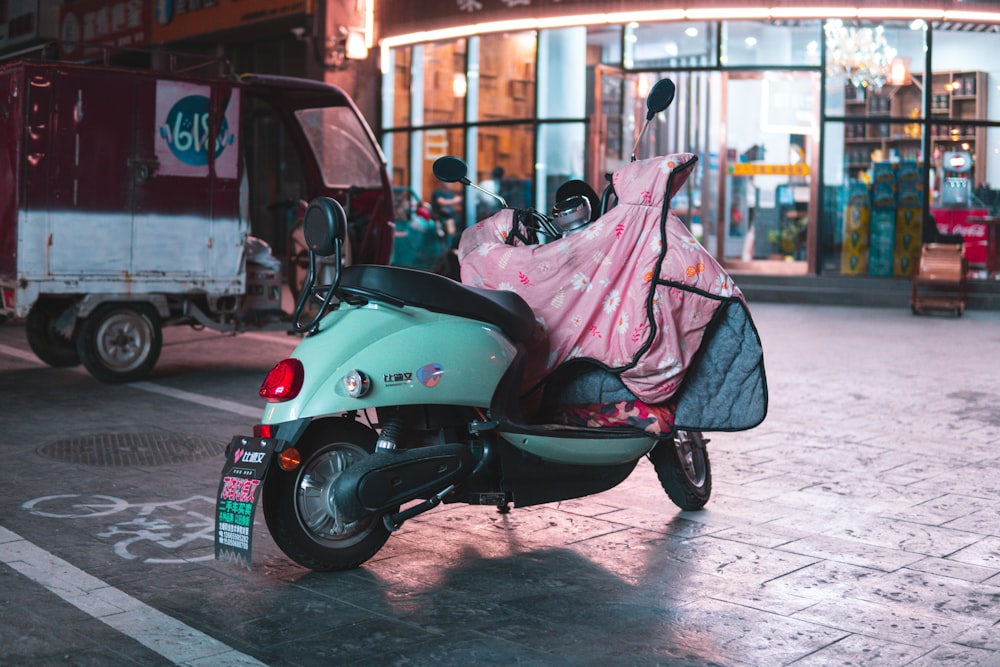 scooter motor verde estacionado na calçada durante o dia