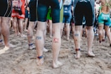 people in blue and red shorts standing on brown sand during daytime