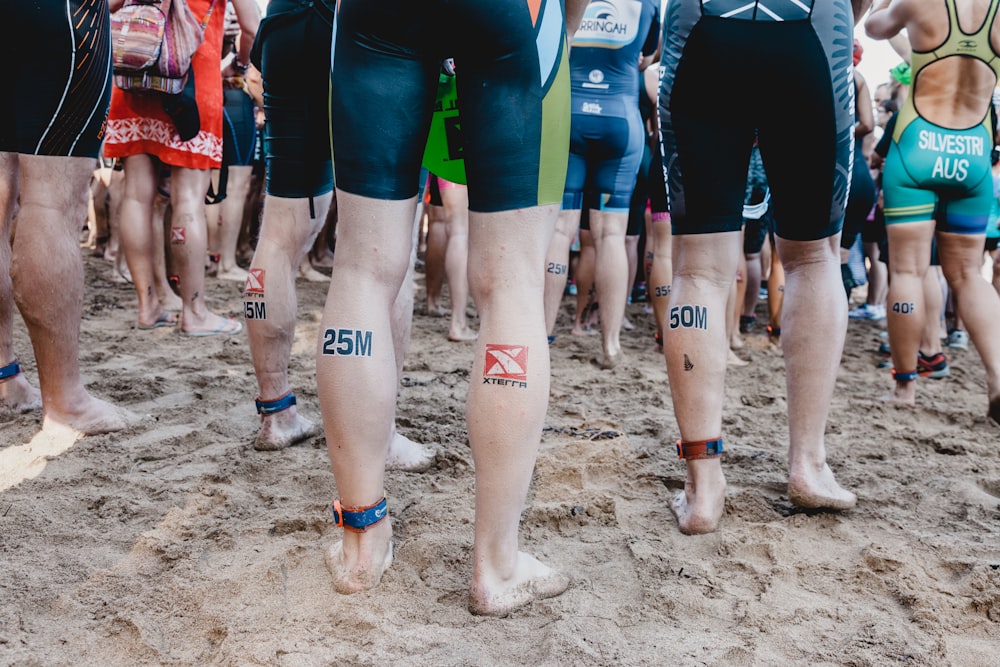 people in blue and red shorts standing on brown sand during daytime