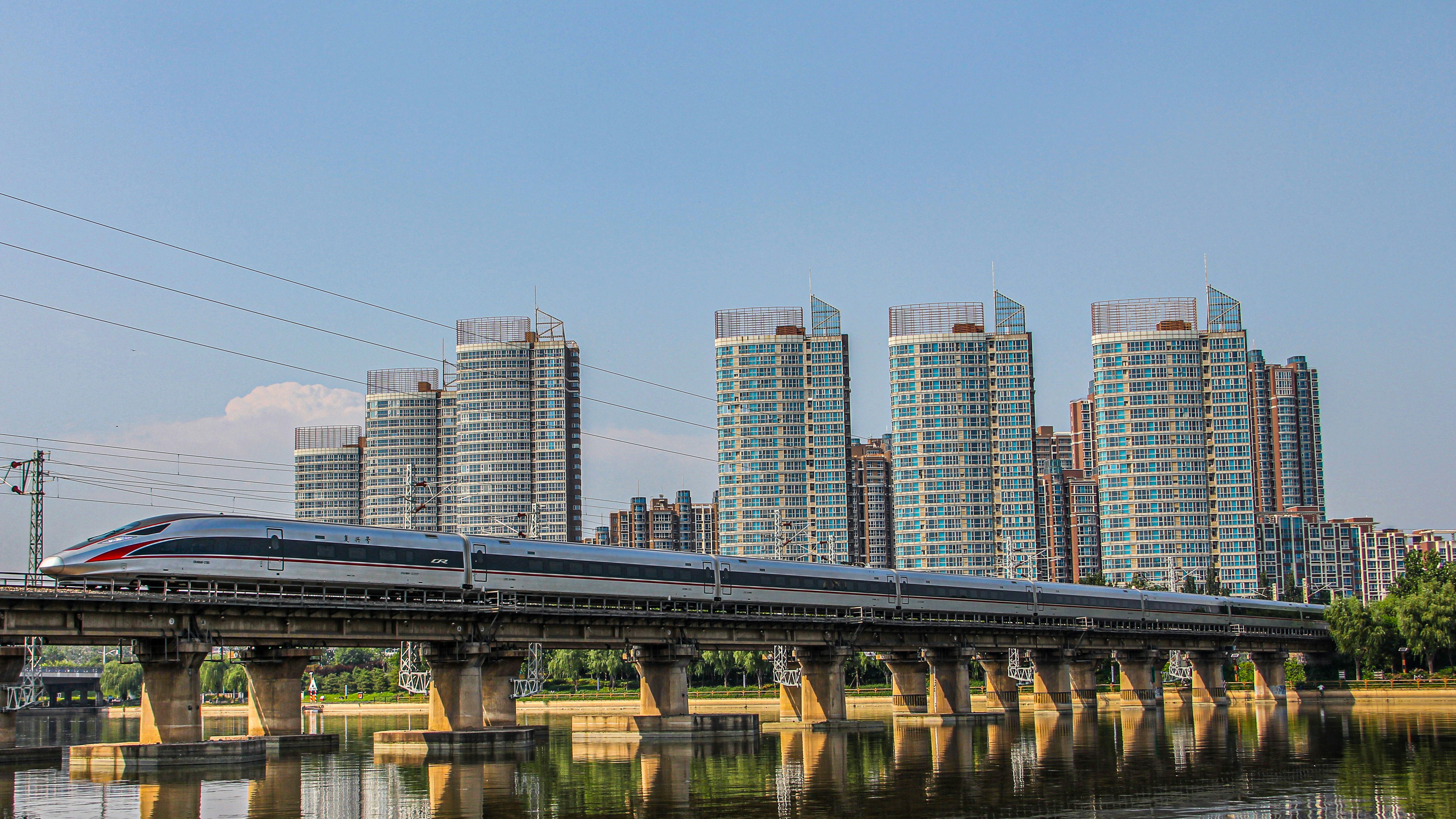 bridge over river near city buildings during daytime