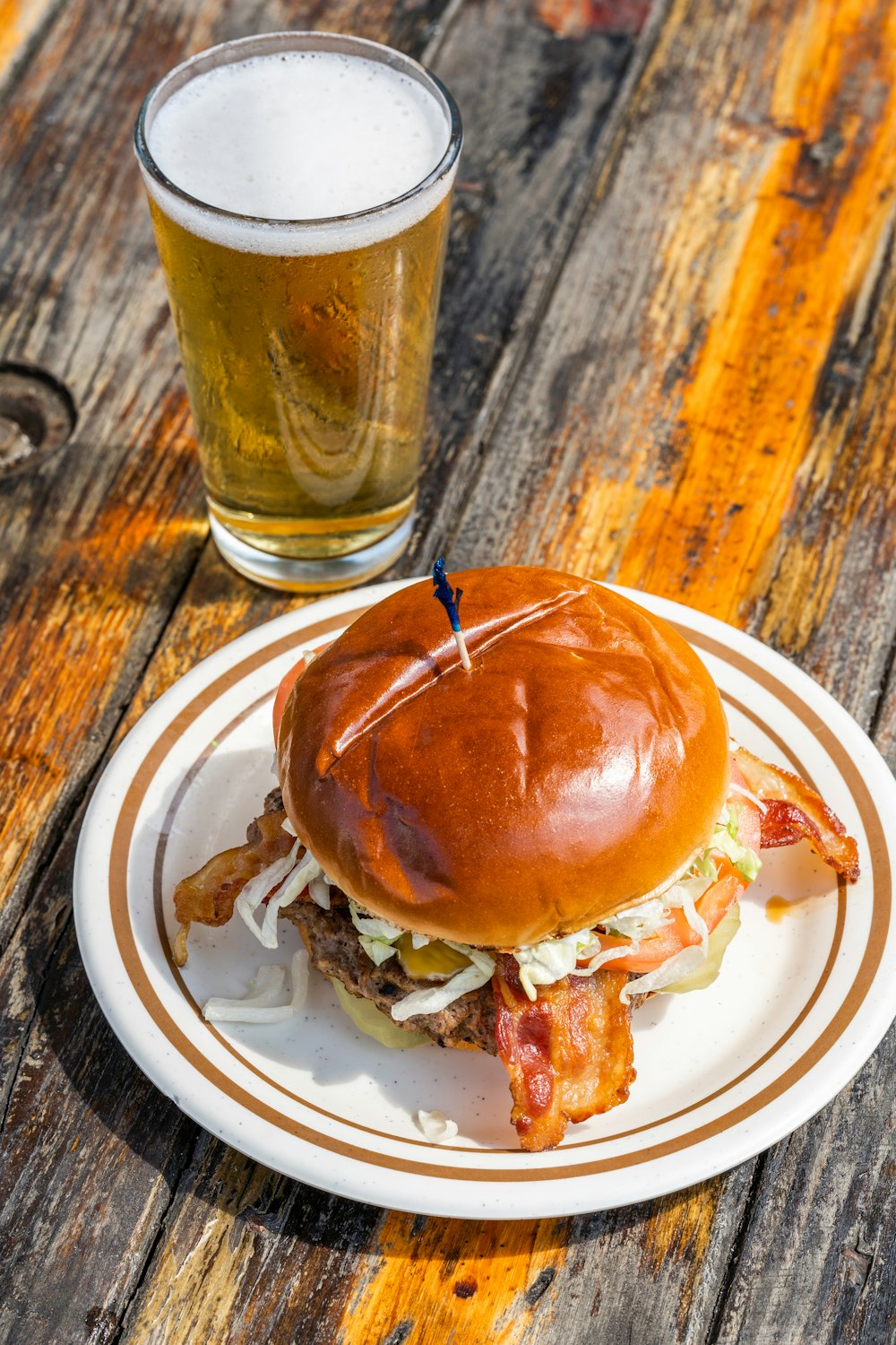 burger on white ceramic plate beside drinking glass