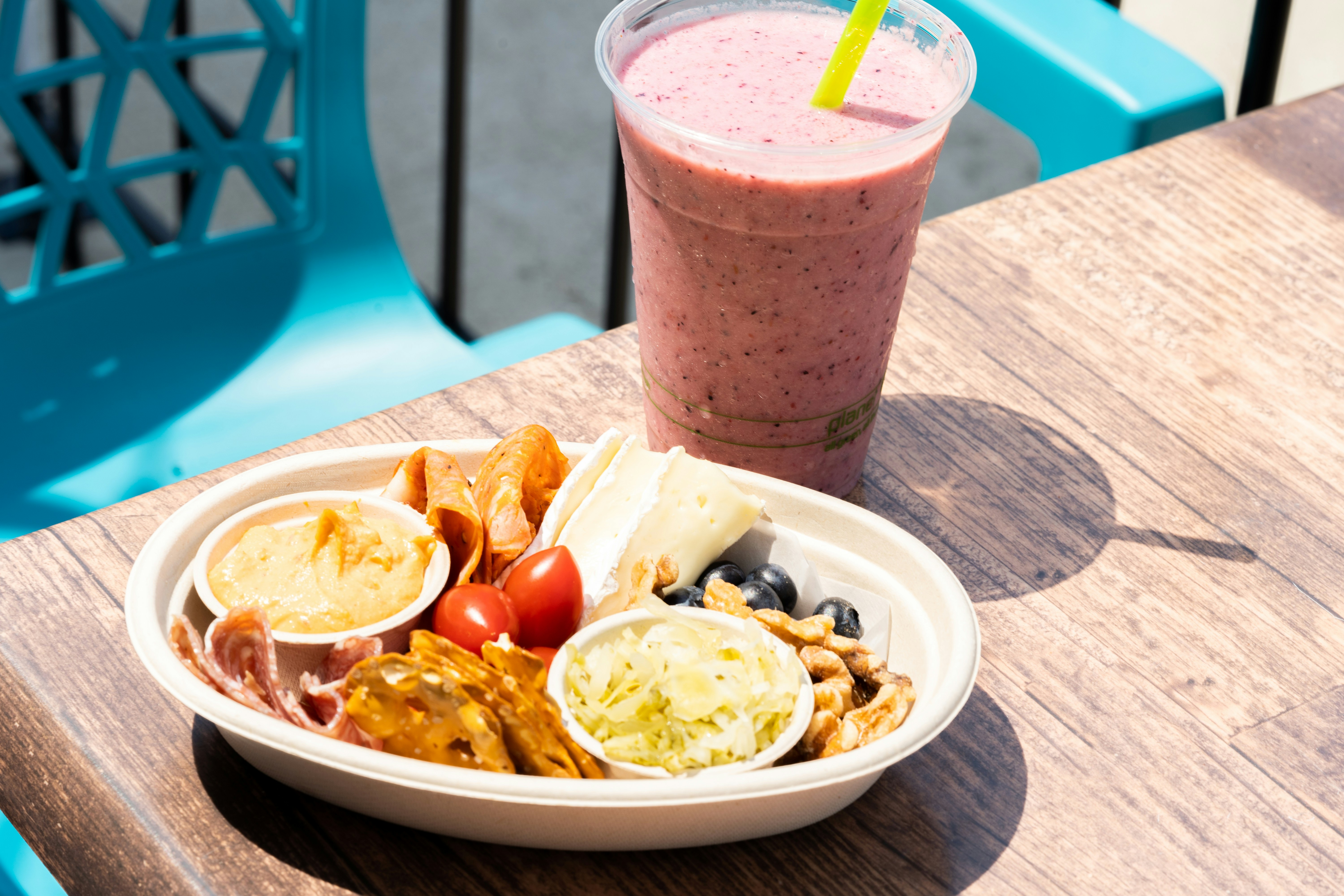 Smoothie and breakfast plate on an outdoor cafe table