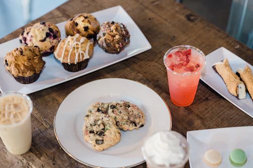 A colorful display of assorted pastries and fast food items on rustic plates.