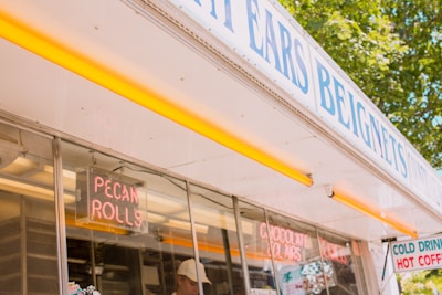 Outdoor scene featuring the Beignet Station on wheels with happy customers enjoying their treats in charming Old Town Spring.