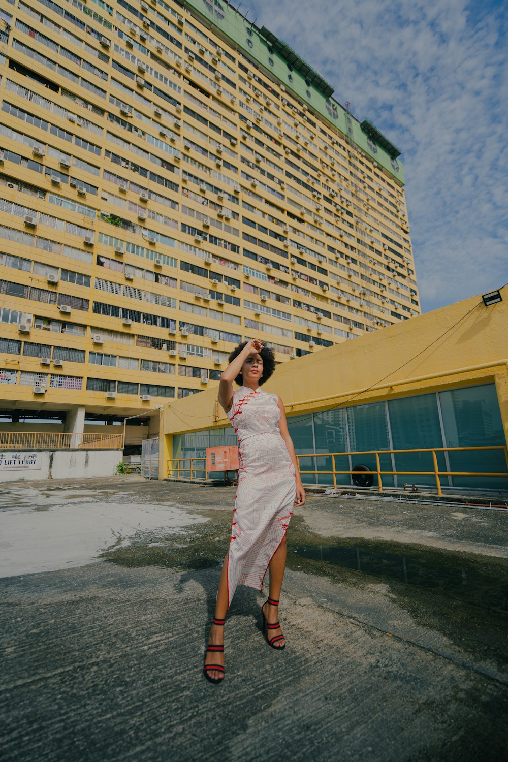 woman in white dress standing near brown building during daytime