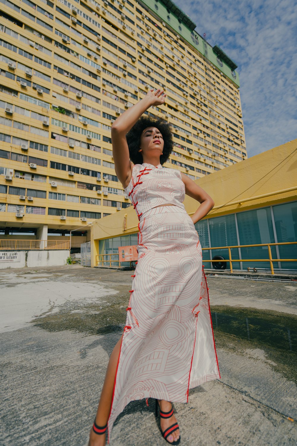 woman in white and red floral dress standing on gray concrete floor during daytime