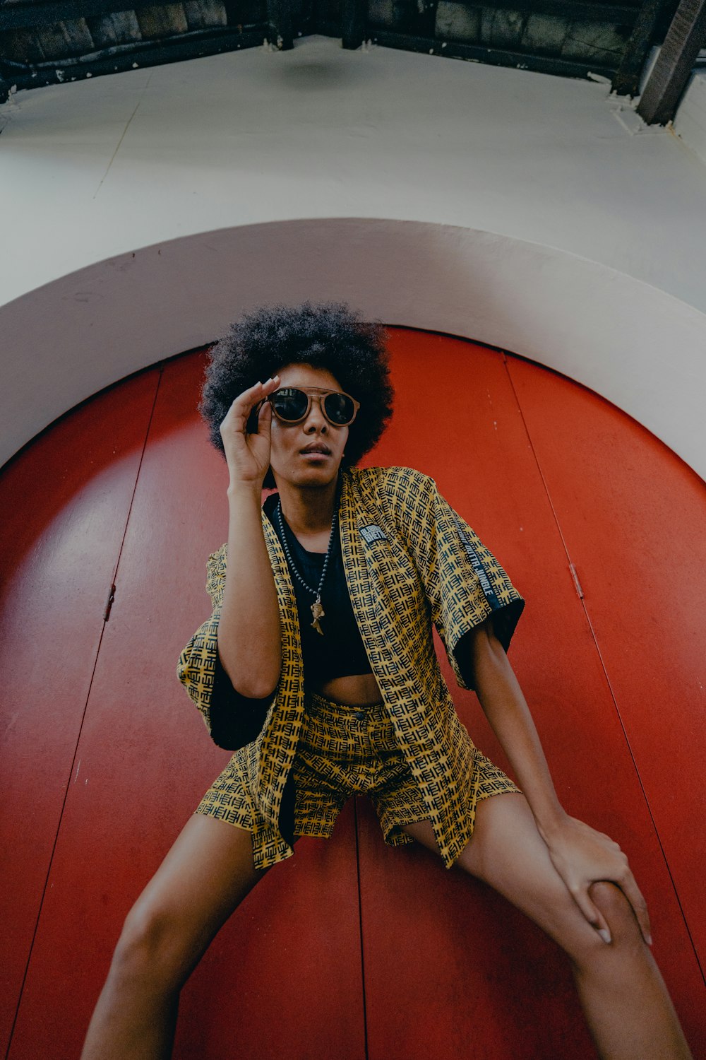 woman in black and white dress wearing black sunglasses sitting on red concrete stairs