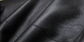 Sleek black microfiber leather samples displayed on a silver metallic surface.