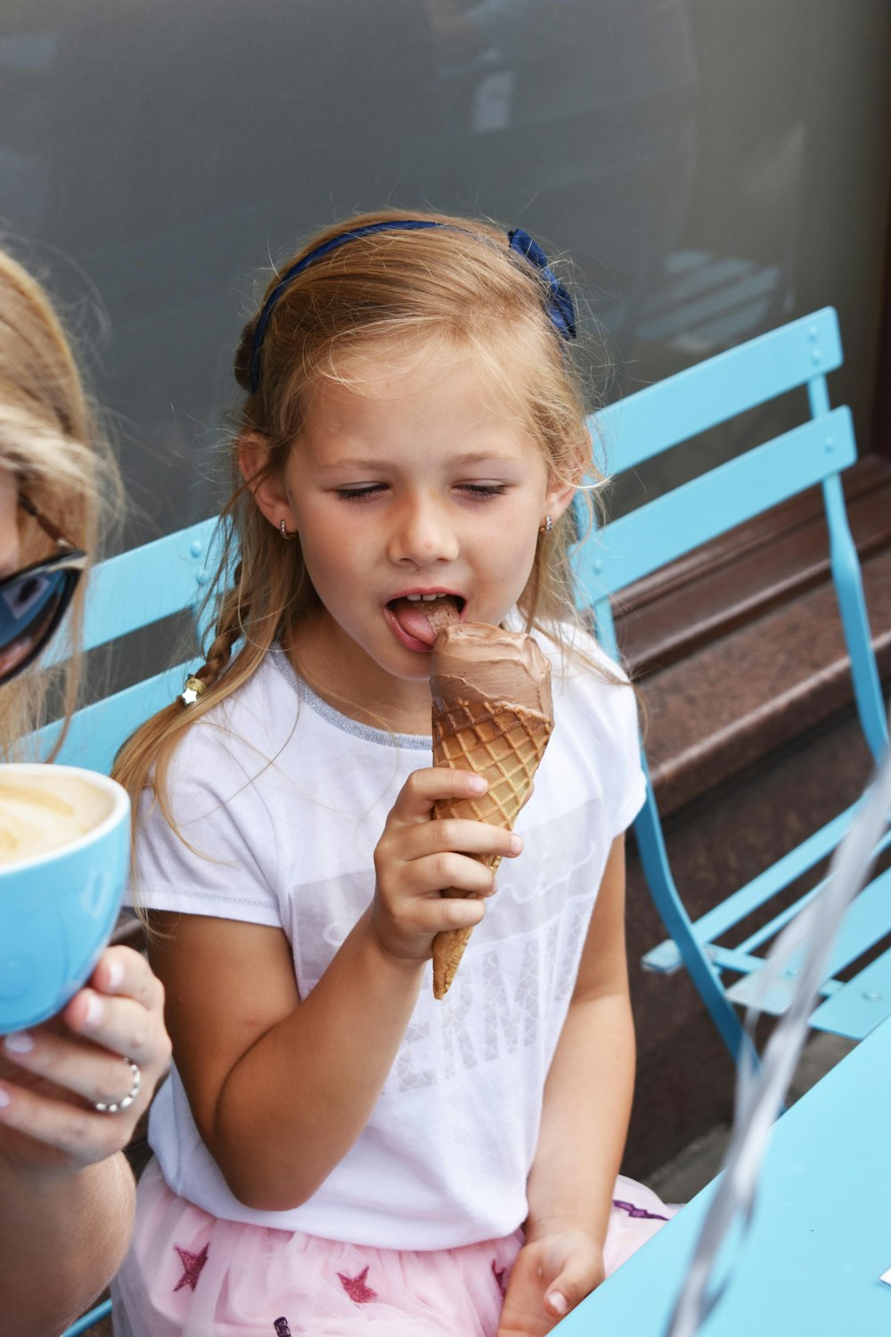 Ragazza in maglietta girocollo bianca che mangia il gelato