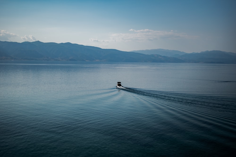 person in black shirt riding on boat on sea during daytime