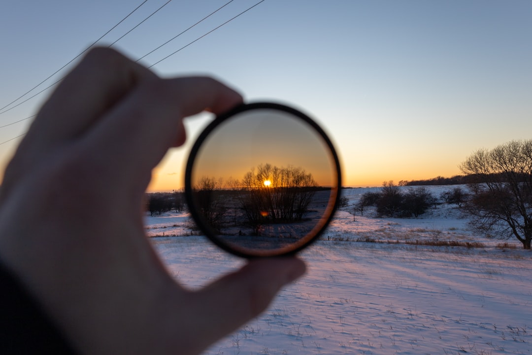 person holding magnifying glass during sunset