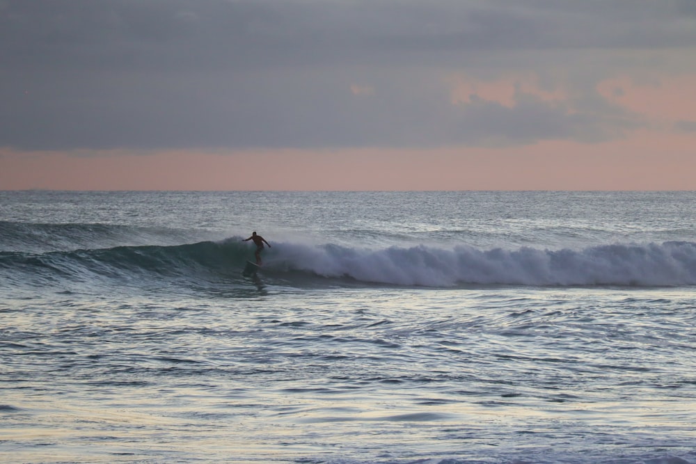 person surfing on sea waves during daytime