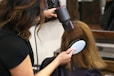 woman holding white and black hair blower