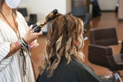 a hair stylist curling volume wefts