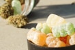 A selection of colorful cannabis-infused gummies in a clear jar.