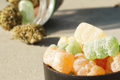 Colorful cannabis-infused edible gummies arranged on a wooden board.