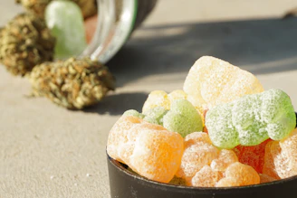 Colorful cannabis-infused edible gummies arranged on a wooden board.