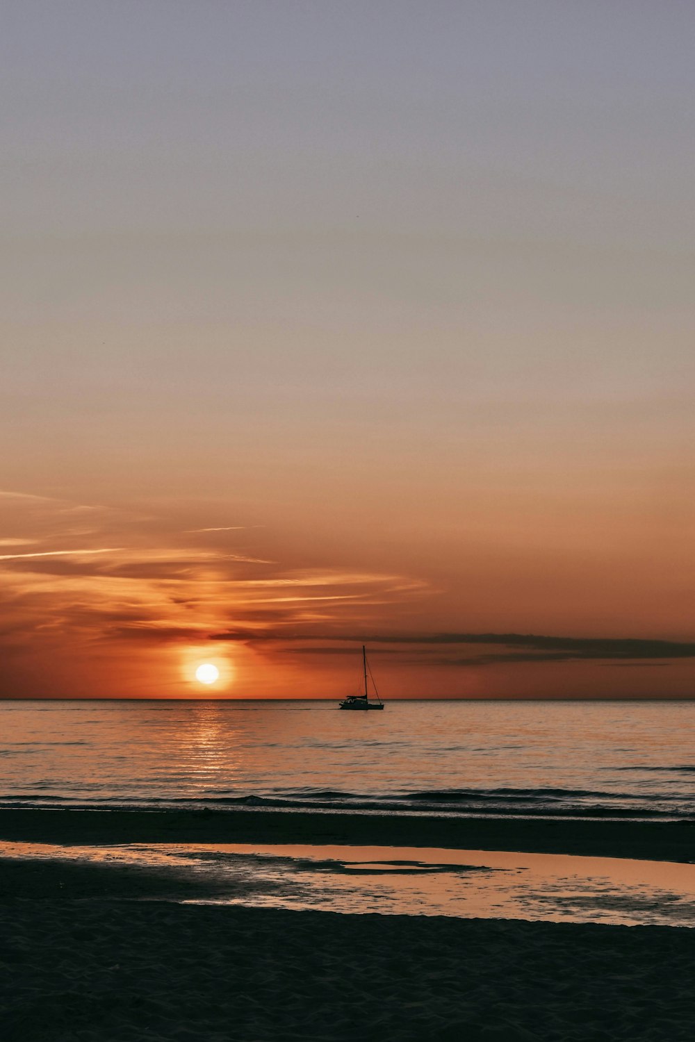 silhouette of boat on sea during sunset