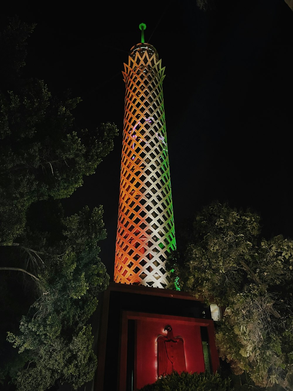 red and white tower near green trees during daytime