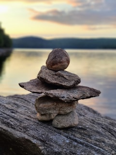 gray stone stack on gray rock near body of water during daytime
