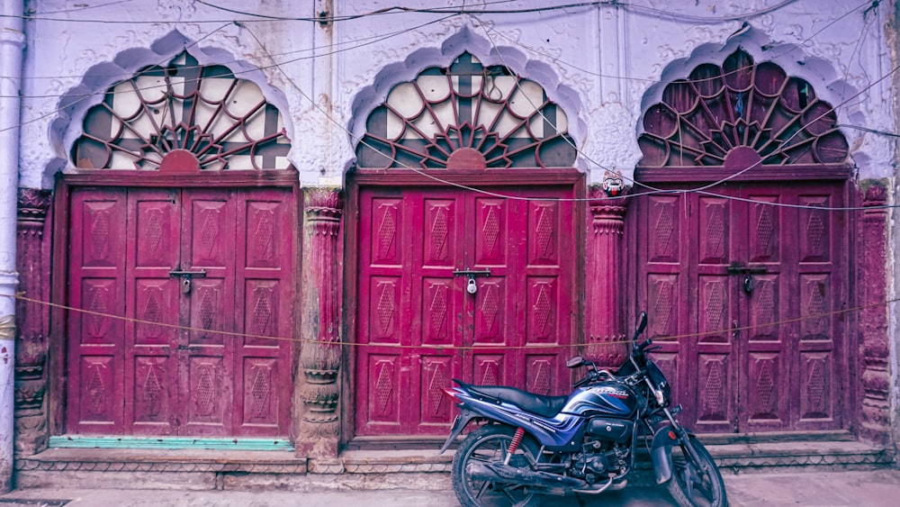 black motorcycle parked beside brown wooden door