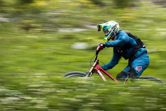 man in blue jacket riding on green and black motocross dirt bike
