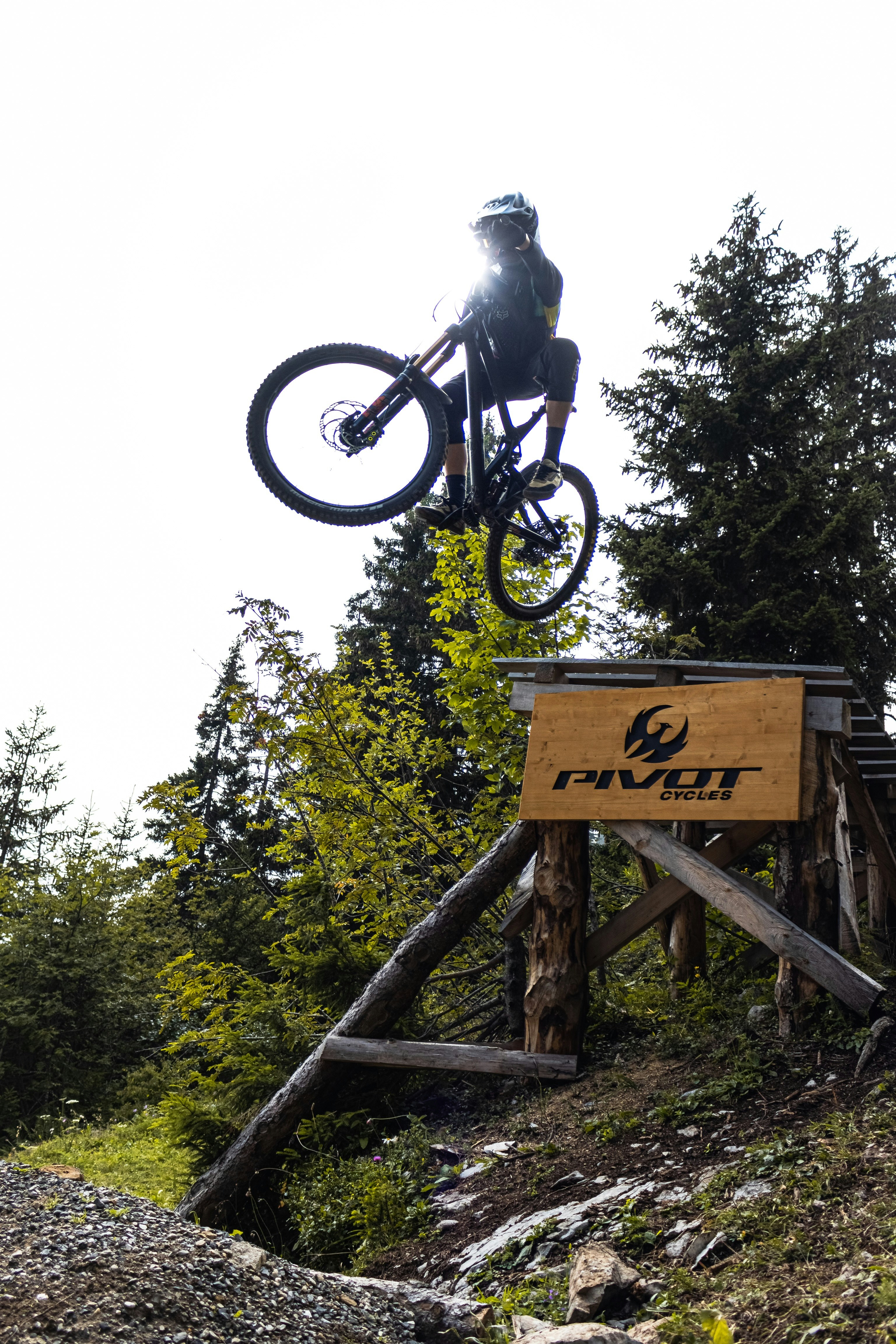 man riding on bicycle on brown wooden bridge