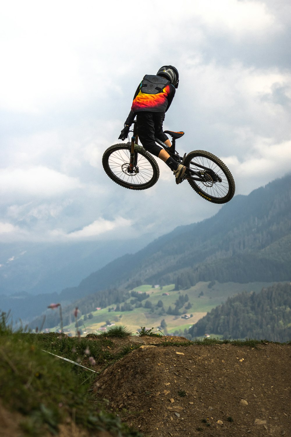 man in red jacket riding motocross dirt bike on green grass field during daytime