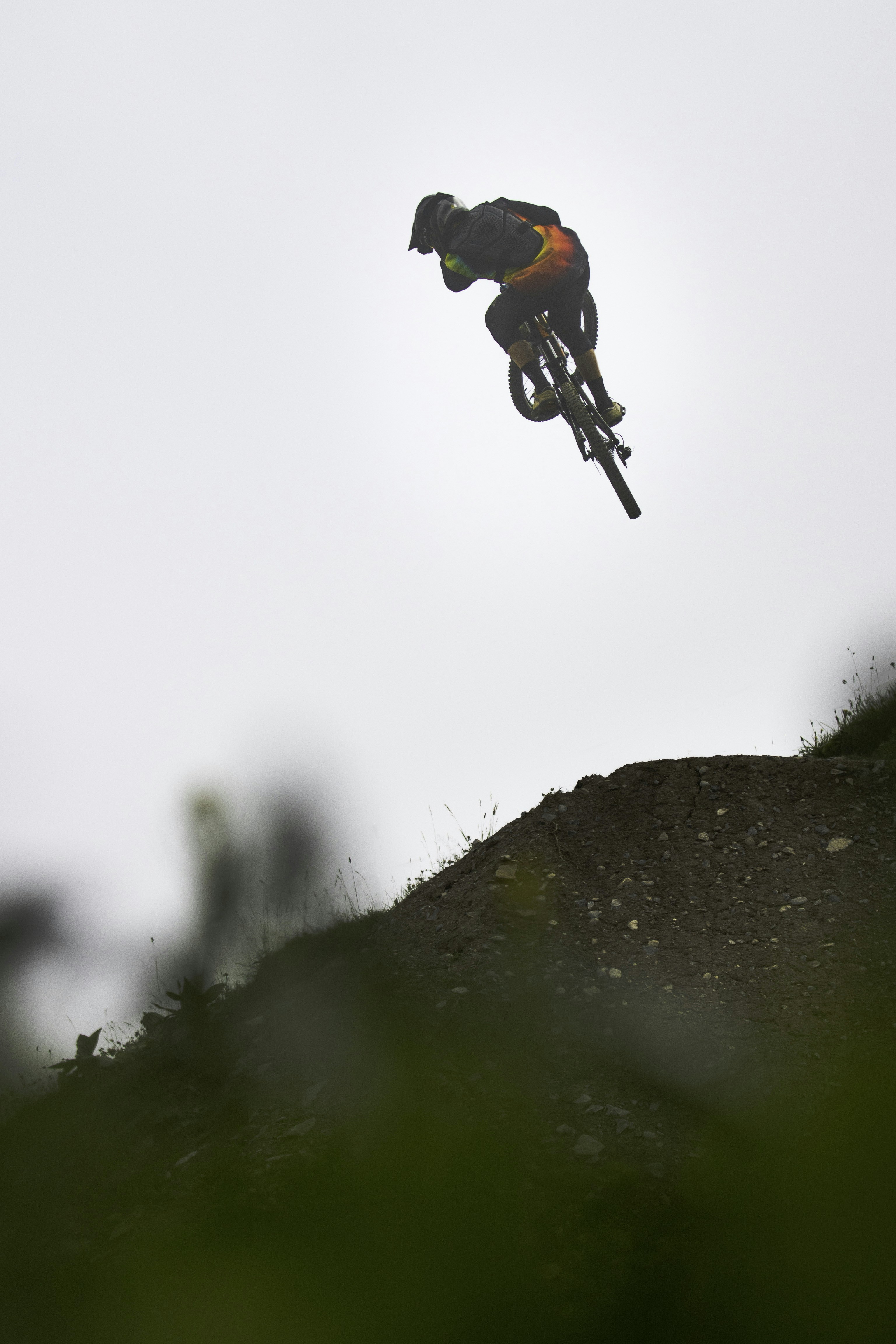 man in black jacket and black pants jumping on cliff during daytime