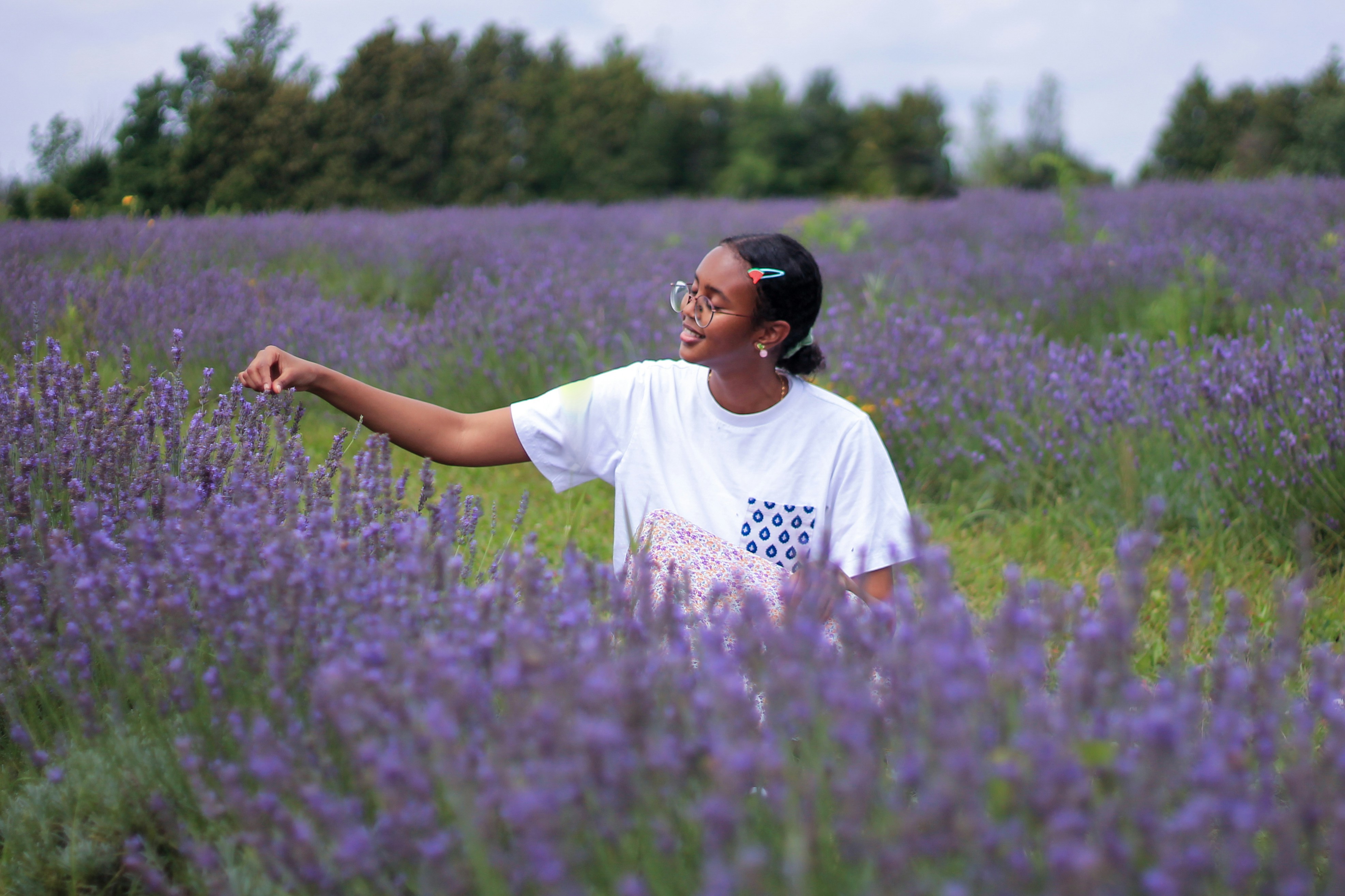 man in white crew neck t-shirt standing on purple flower field during daytime