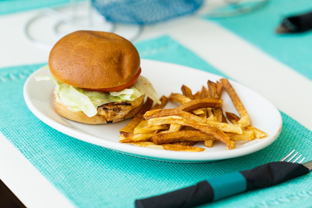 Burger und Pommes auf weißem Keramikteller