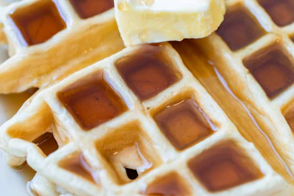 Close-up of homemade pancakes drizzled with maple syrup and butter