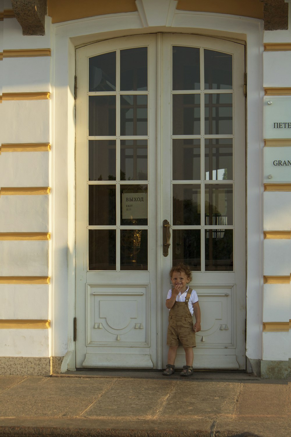 woman in brown coat standing beside white wooden door