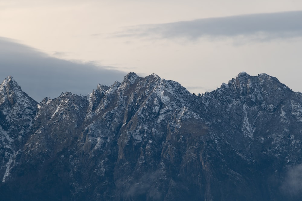 gray and black rocky mountain under white cloudy sky during daytime