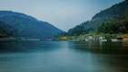 body of water near green mountain during daytime