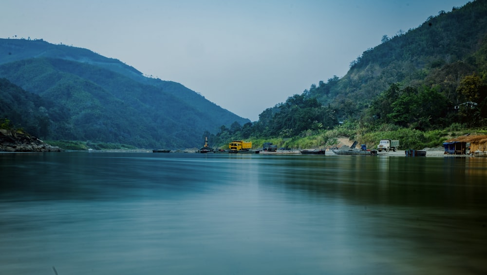 body of water near green mountain during daytime