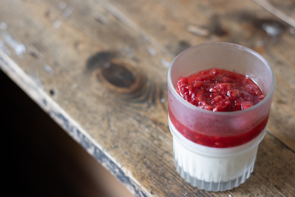 red and white plastic container on brown wooden table