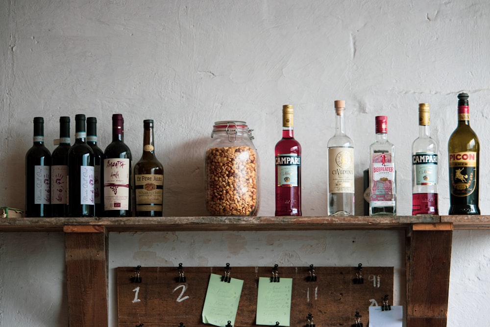 assorted bottles on brown wooden shelf