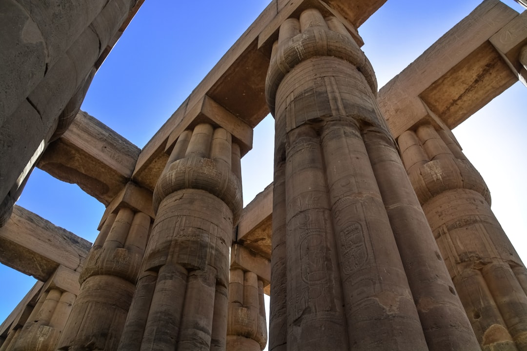 low angle photography of brown concrete building under blue sky during daytime