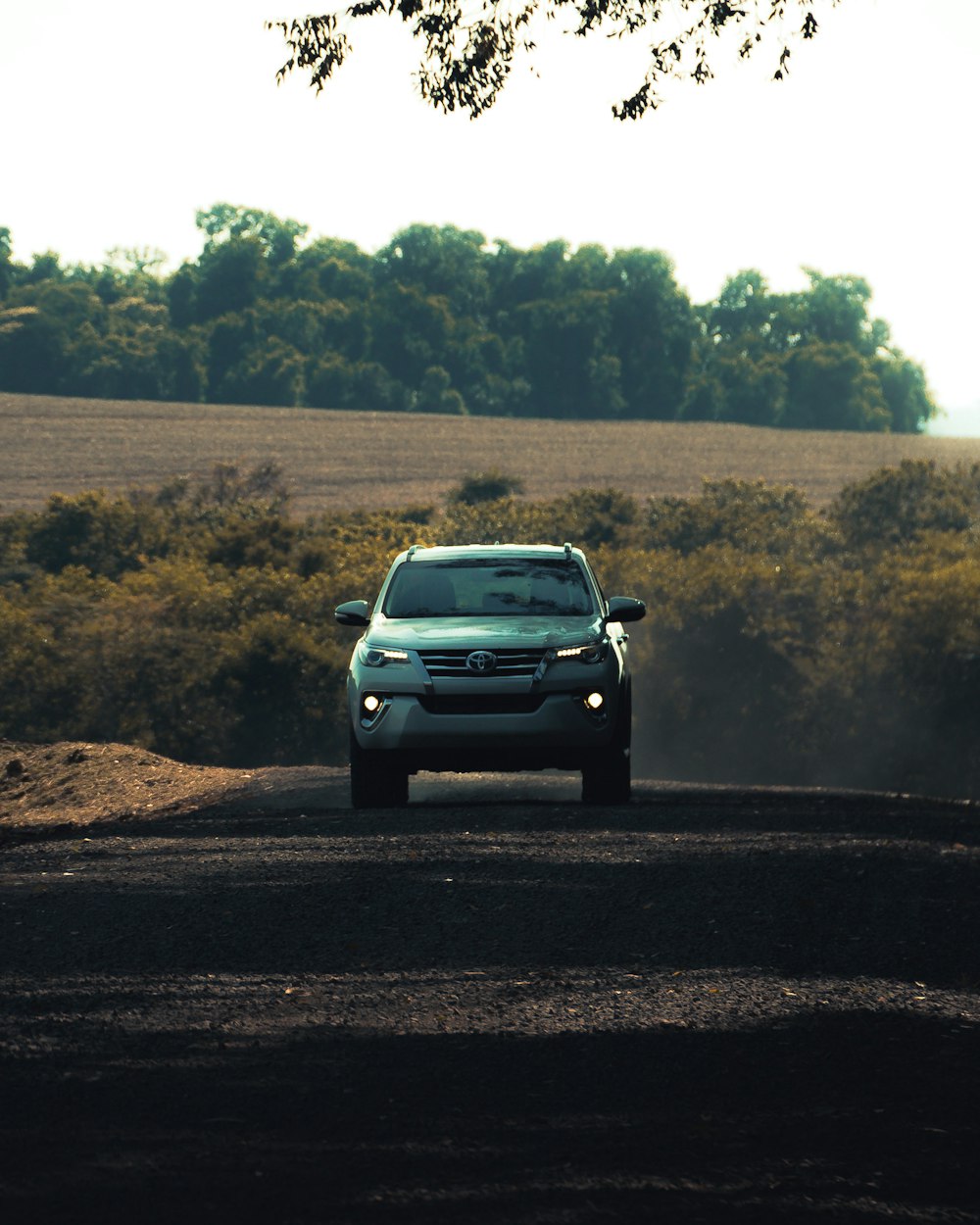 gray car on dirt road during daytime